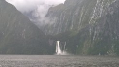 Military boat at base of waterfall, Milford Sound